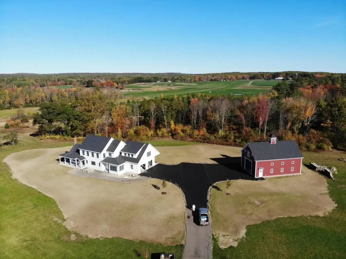 An aerial view of a house and barn in a field