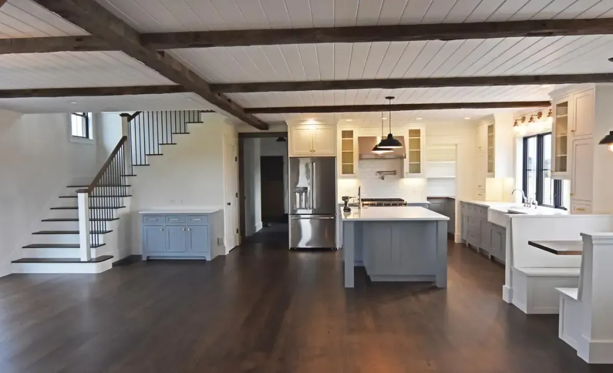 An empty kitchen with a staircase leading to the second floor