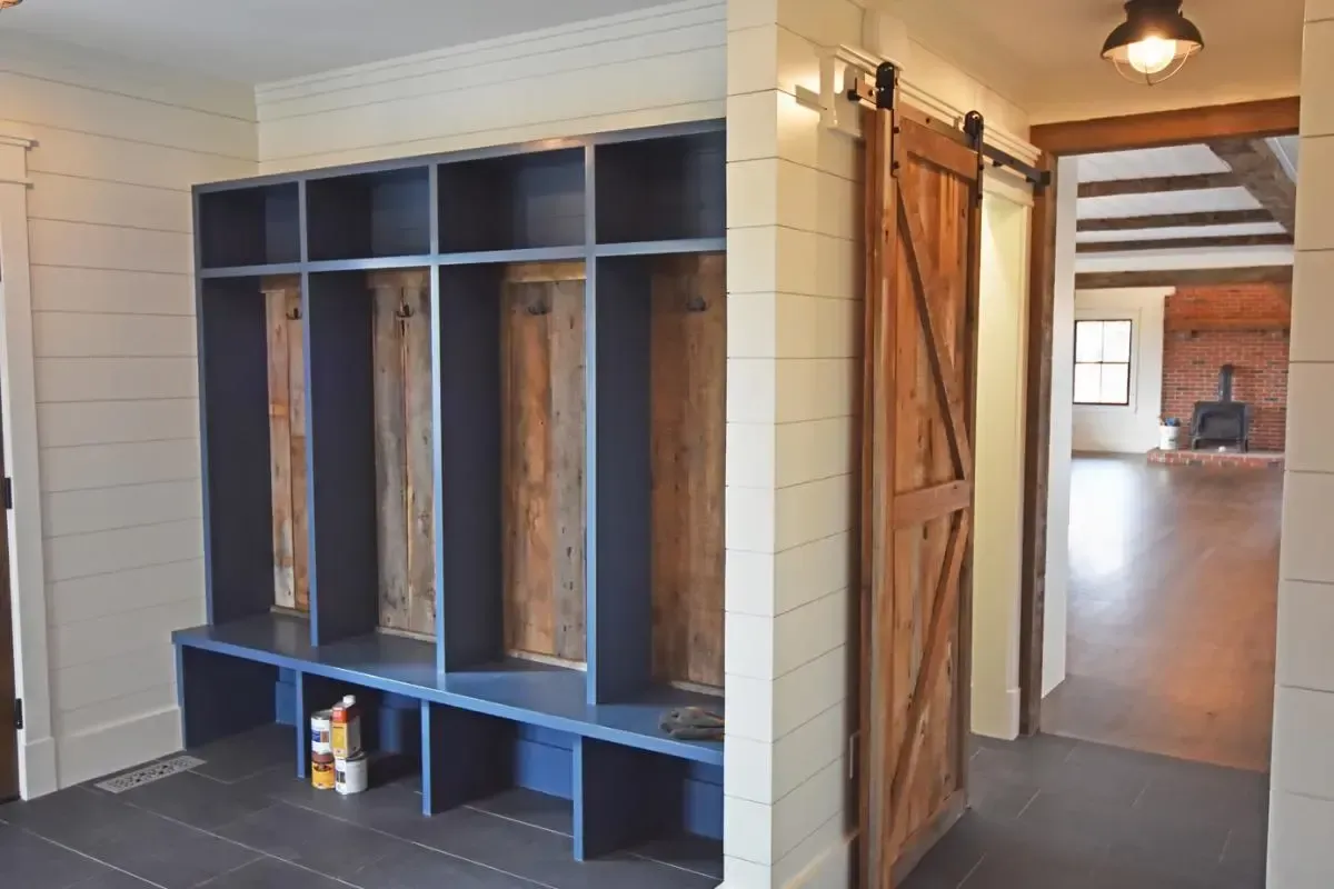 A hallway with a sliding barn door and lockers