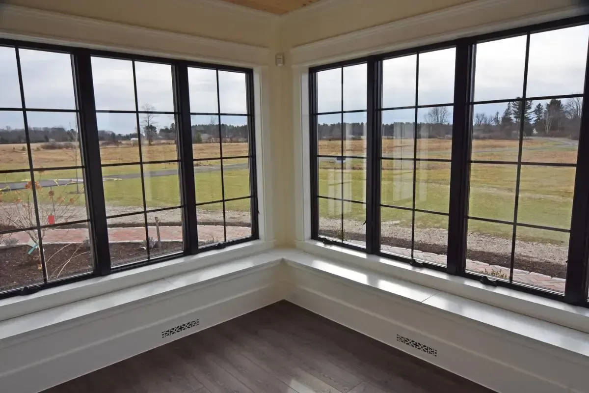 A room with a lot of windows and a view of a field.