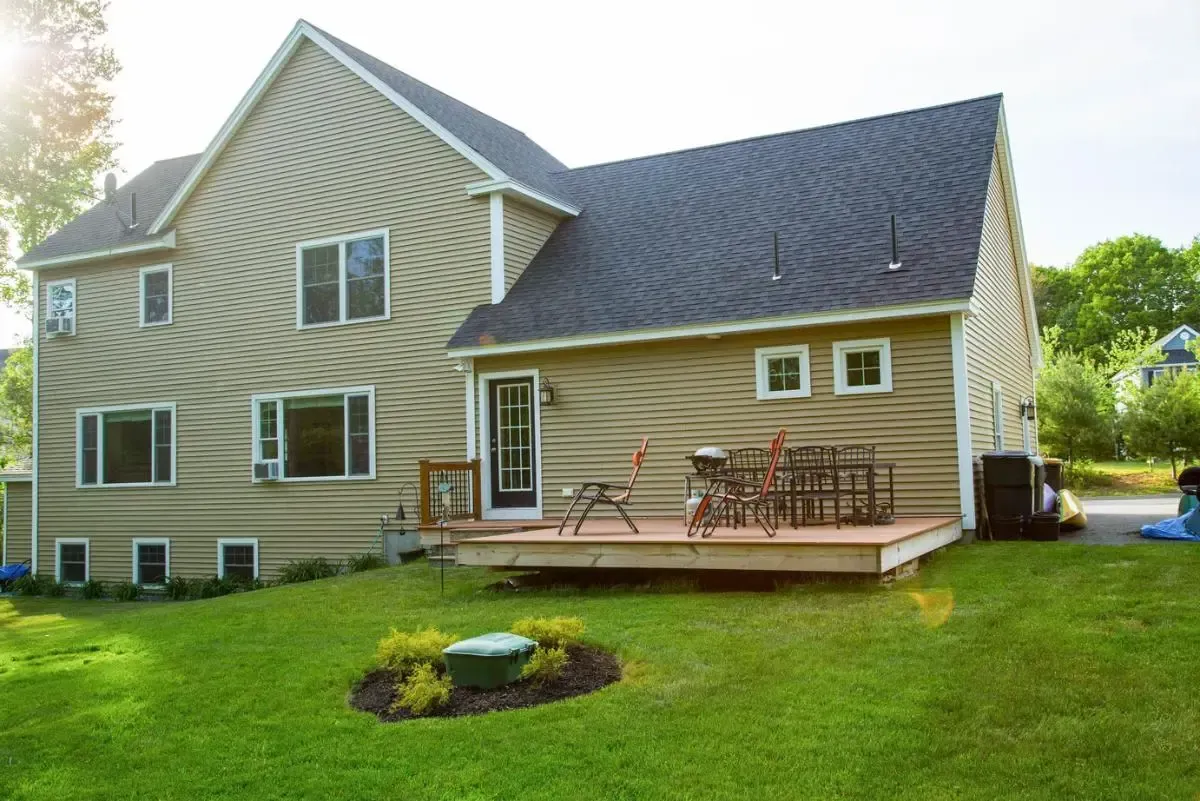 A large house with a large deck in the backyard.