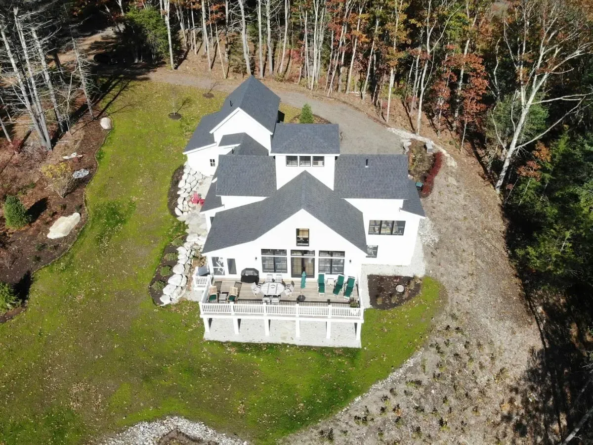 An aerial view of a large white house surrounded by trees.