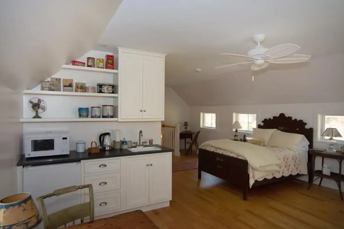 A bedroom with a ceiling fan and a bed
