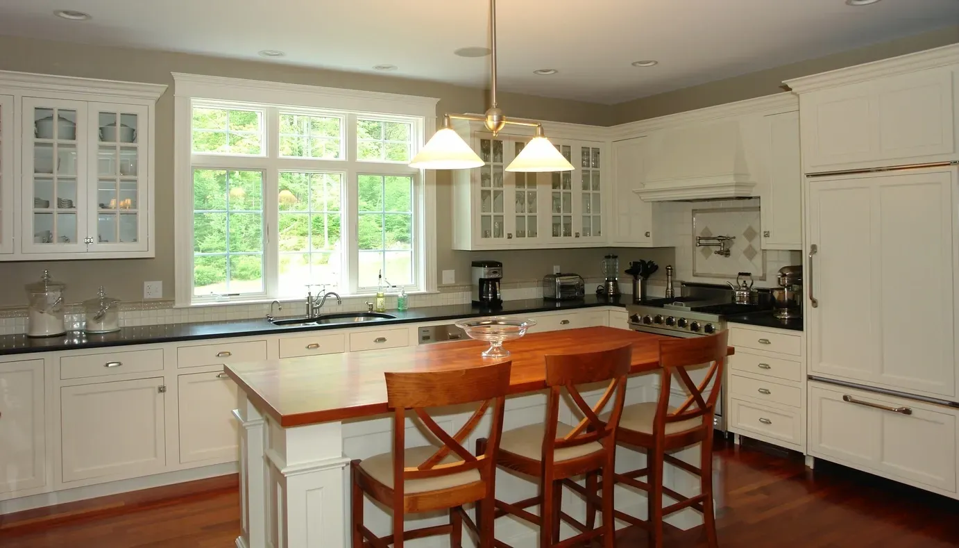 A kitchen with white cabinets and a large island
