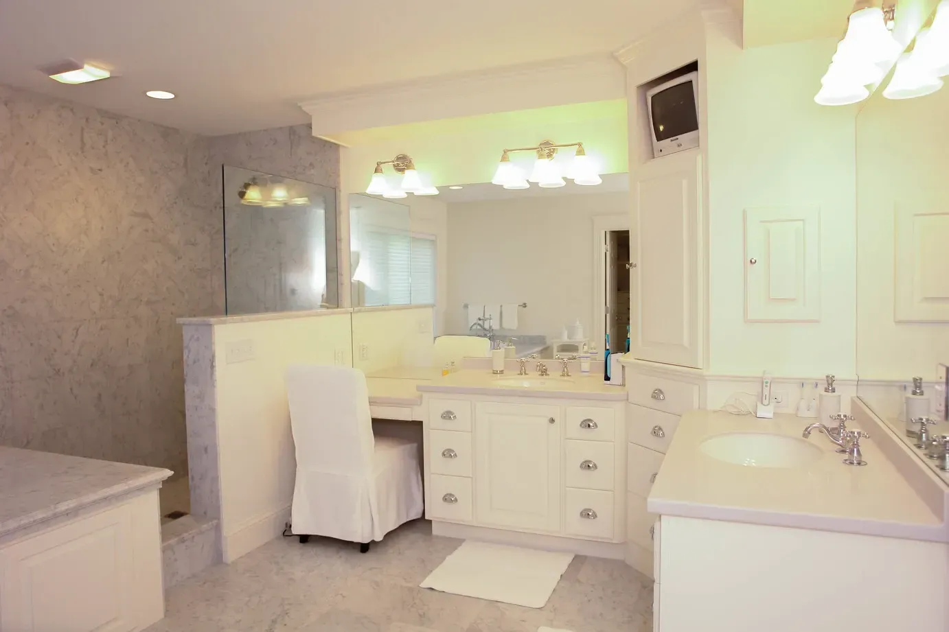 A bathroom with two sinks , a tub , and a mirror.