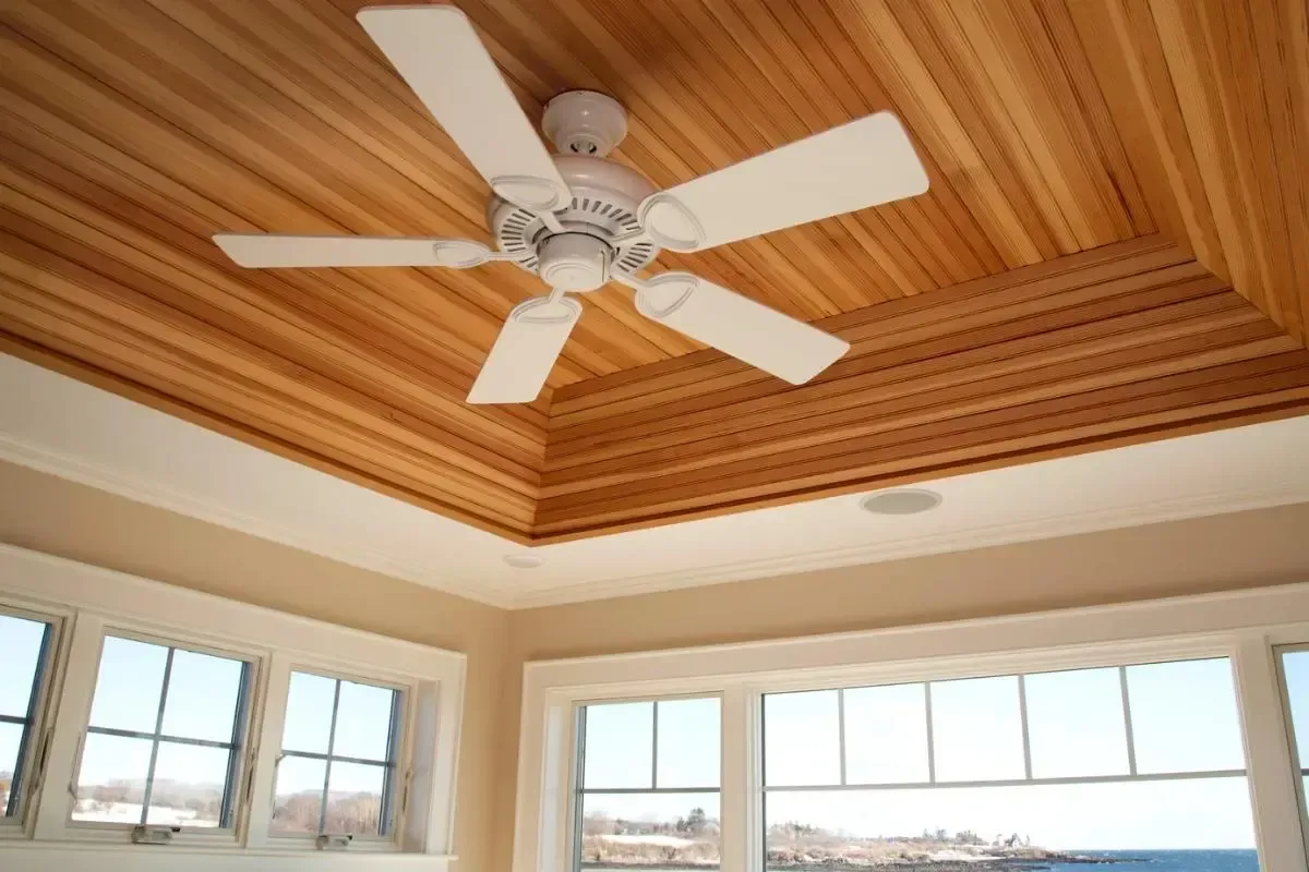 Custom designed  light colored wood ceiling with a ceiling fan.