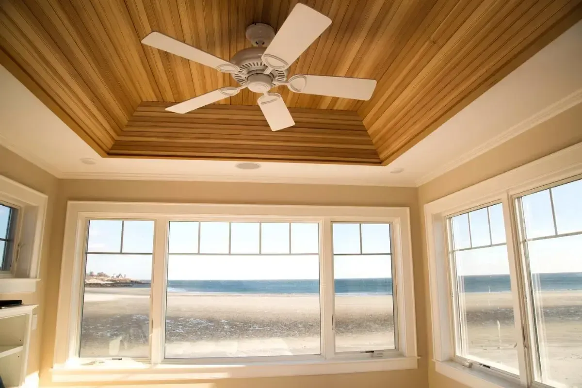 A room with a ceiling fan and a view of the ocean