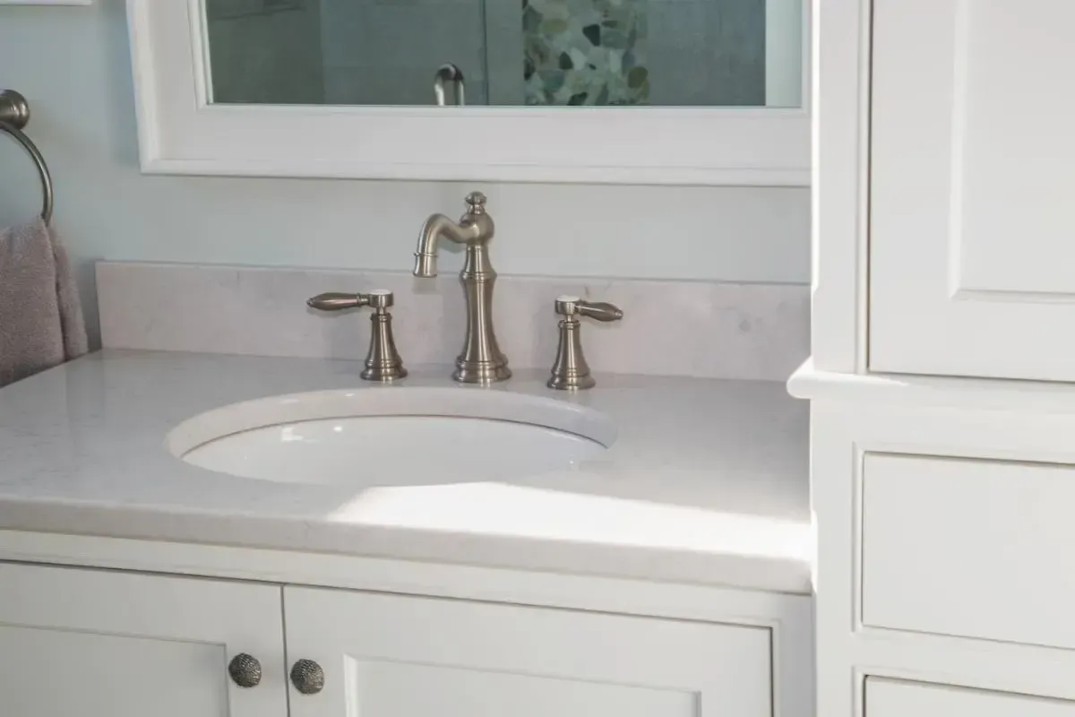 A bathroom vanity with a sink , mirror and cabinets.