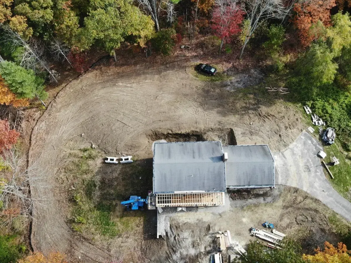 An aerial view of a house in the middle of a forest.