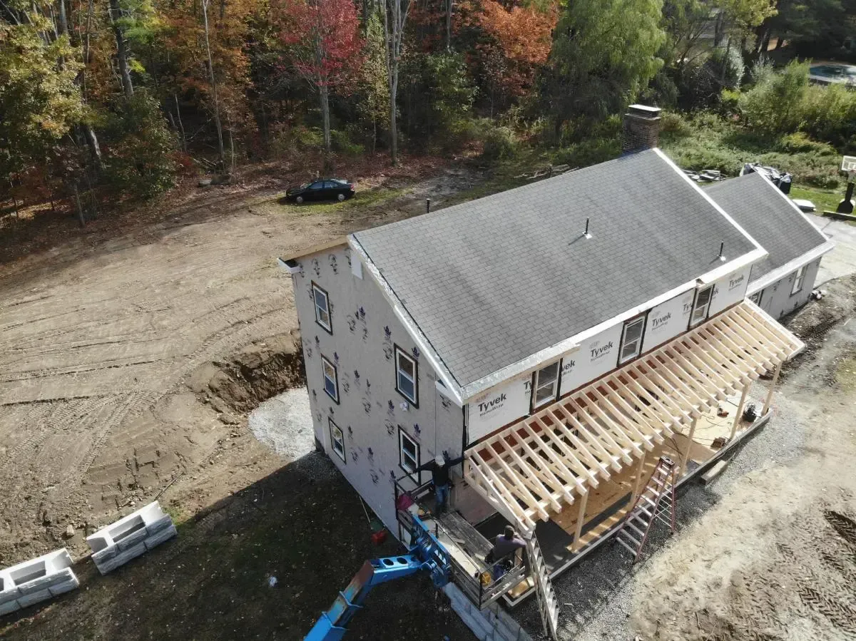 An aerial view of a house under construction in the woods.