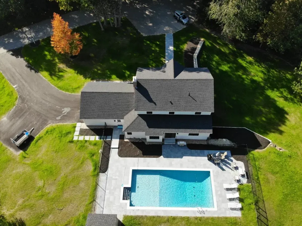 An aerial view of a house with a large swimming pool