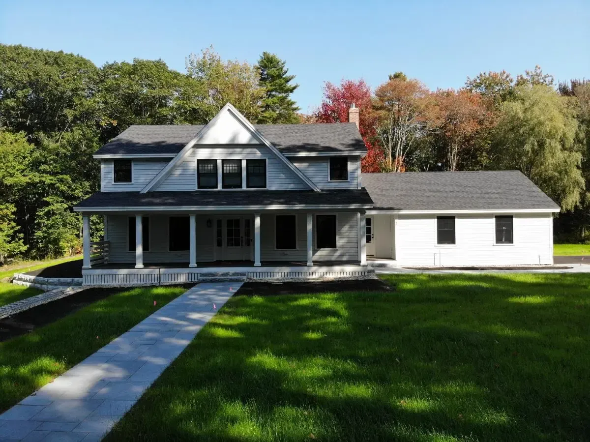 A large white house with a porch and a walkway
