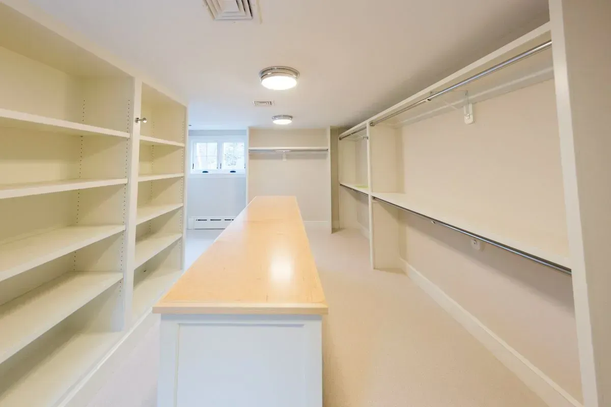 A walk in closet with lots of shelves and hanging racks