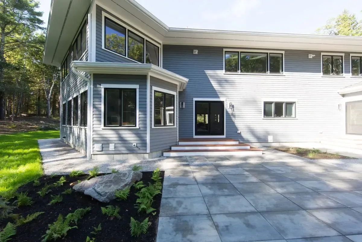 A large house with a lot of windows and a patio in front of it.