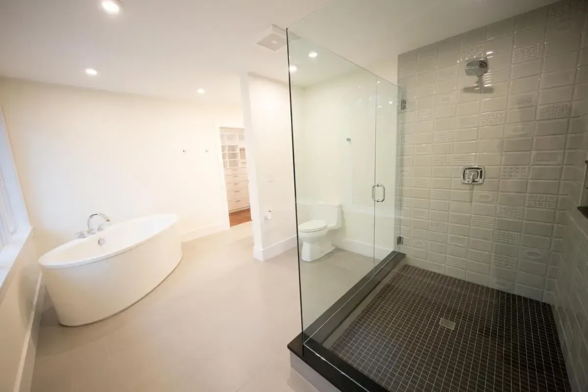A bathroom with a tub , toilet , shower and walk in shower.