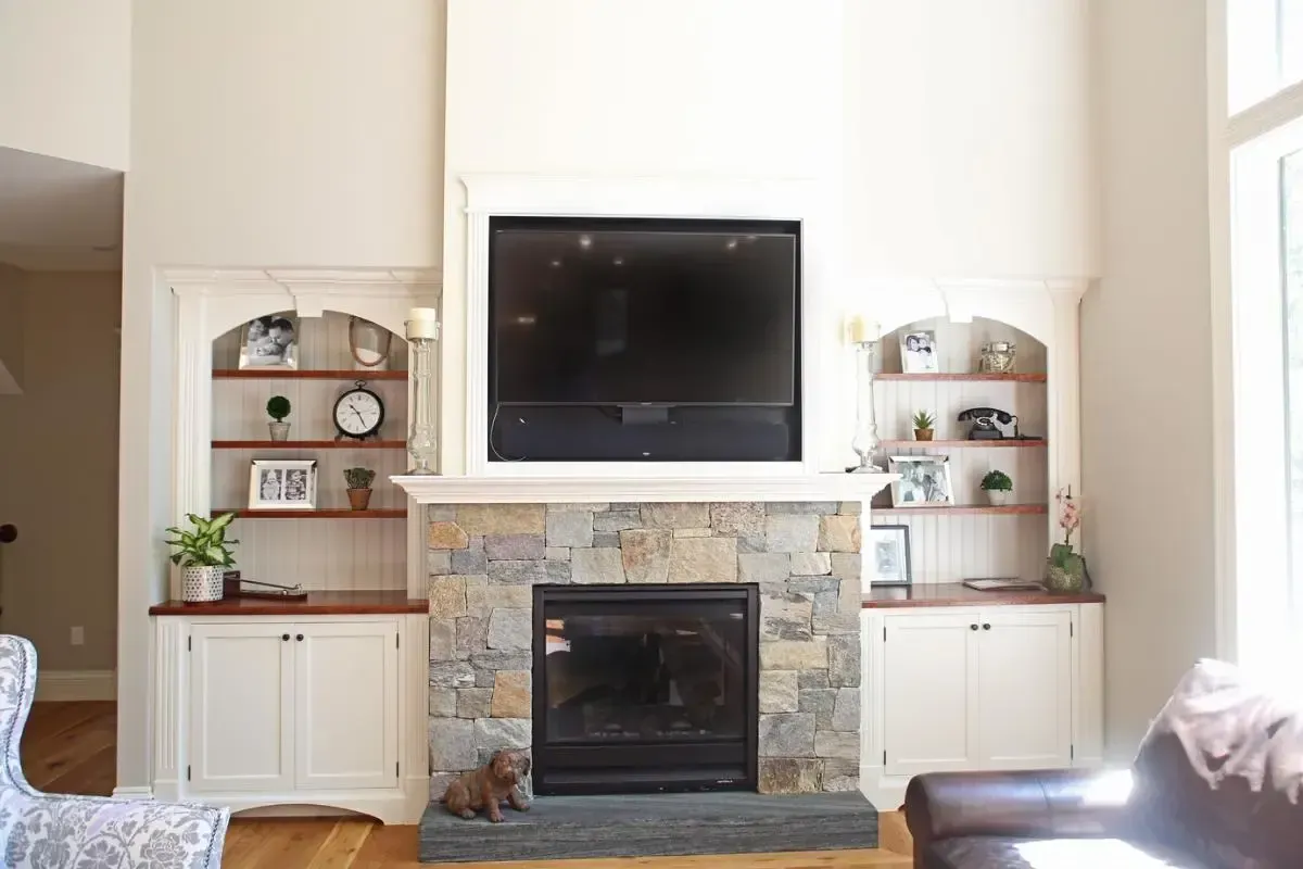 A living room with a fireplace and a flat screen tv above it.