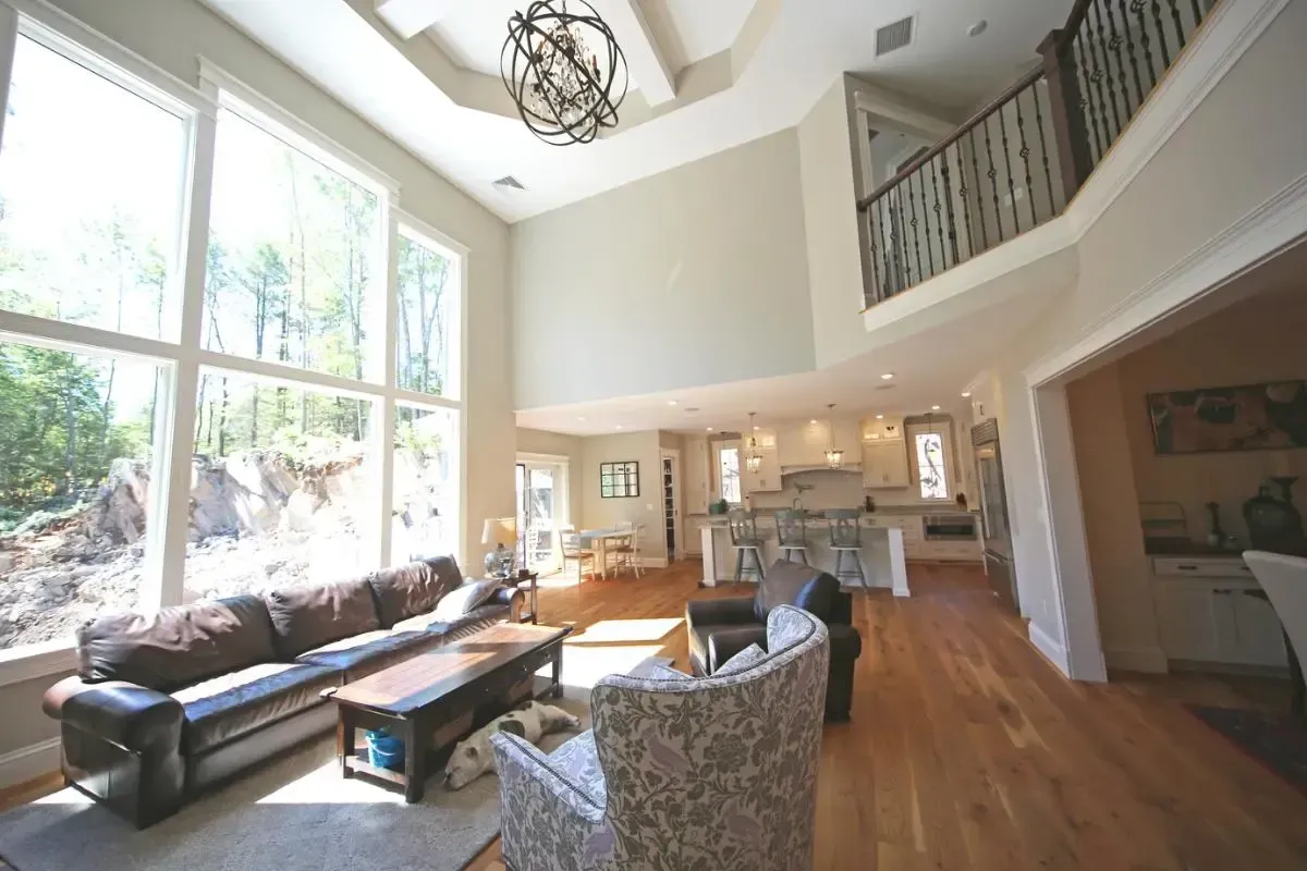 A living room with a couch and chairs and lots of windows