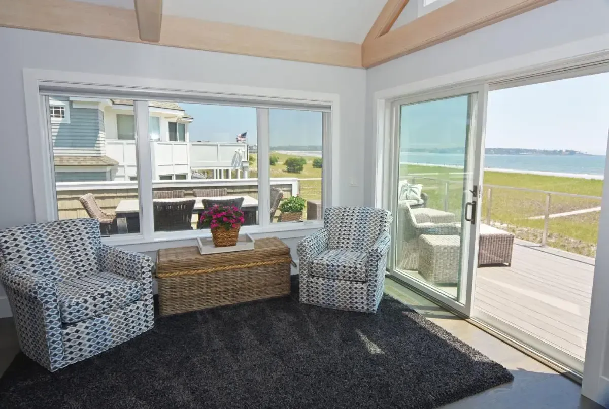 A living room with a view of the ocean and a sliding glass door