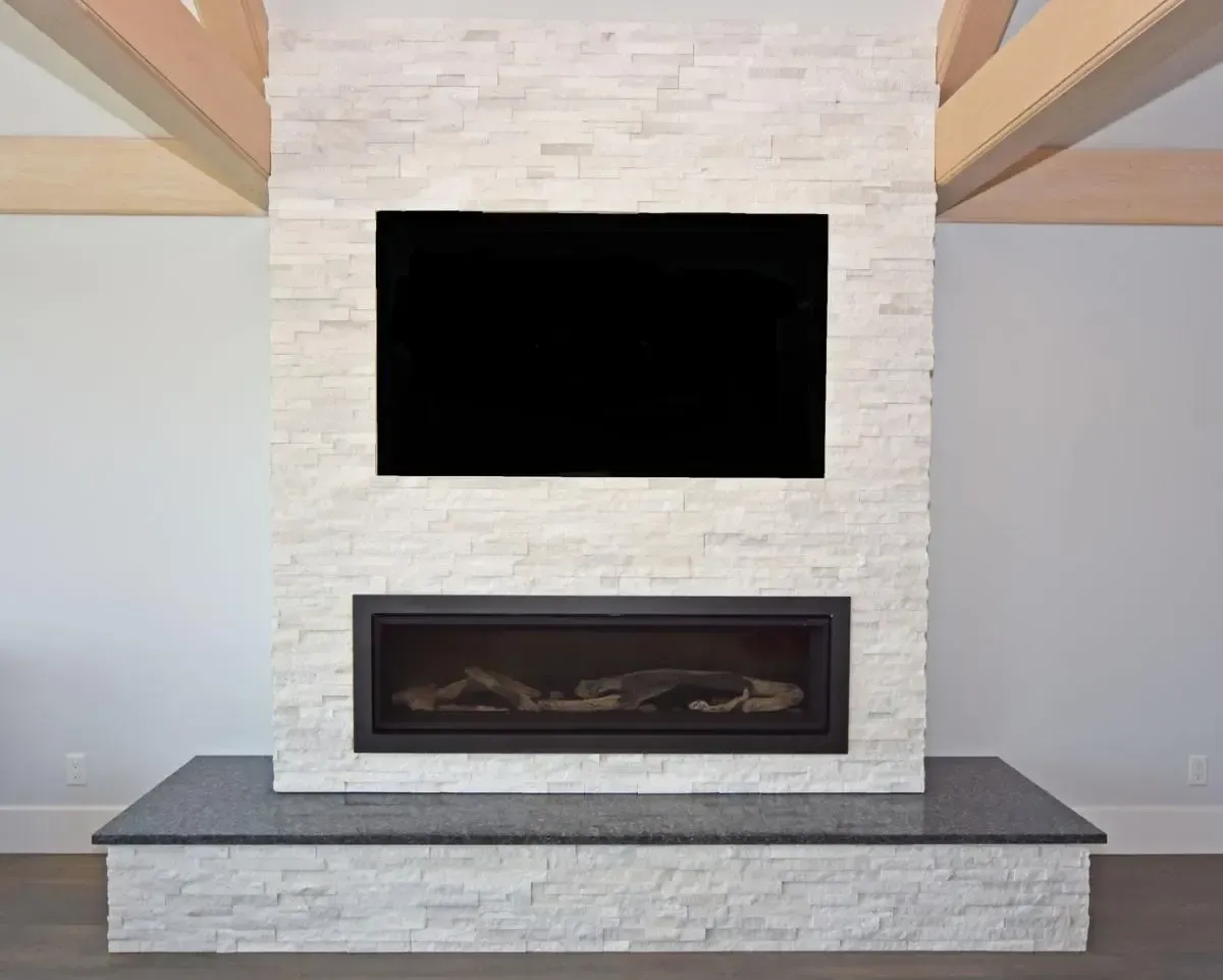 A fireplace with a flat screen tv mounted on the wall above it.