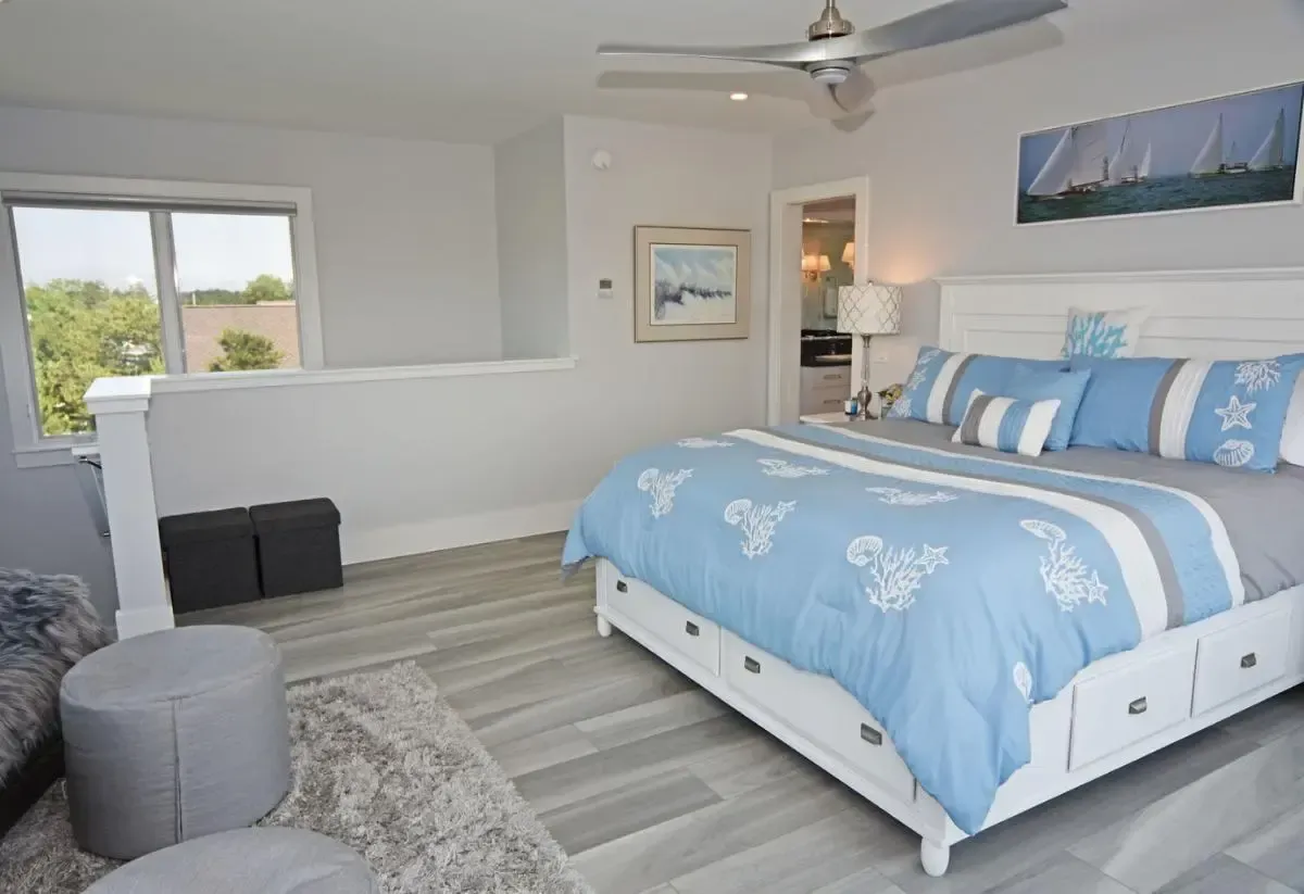 A bedroom with a king size bed and a ceiling fan.