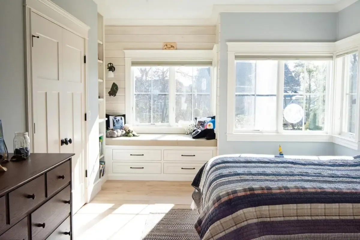 A bedroom with a bed and a window seat