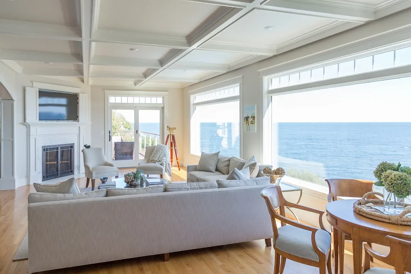 A living room filled with furniture and a table with a view of the ocean.