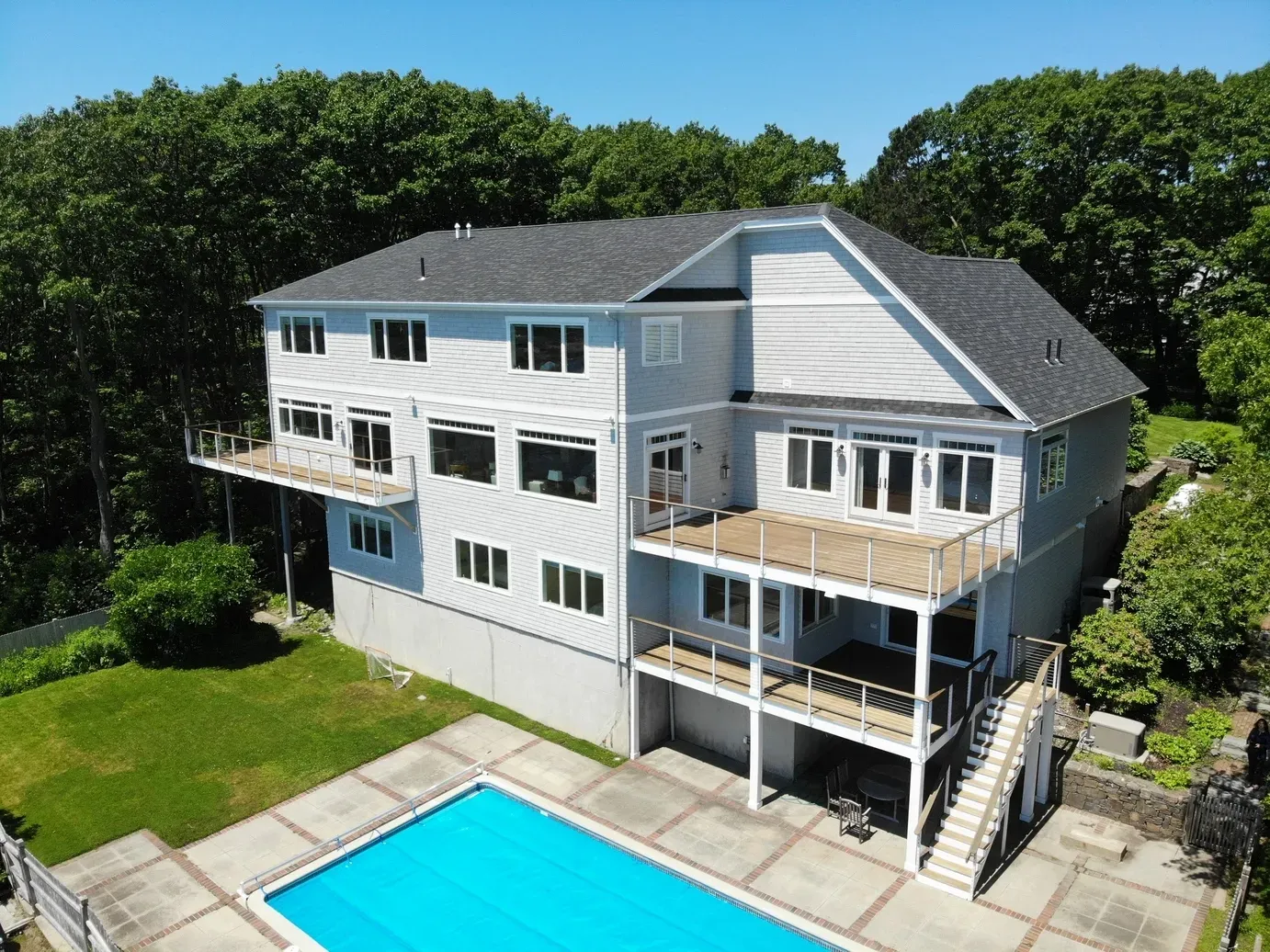 An aerial view of a large house with a large swimming pool