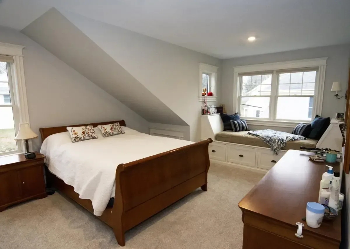 A bedroom with a sleigh bed and a window seat