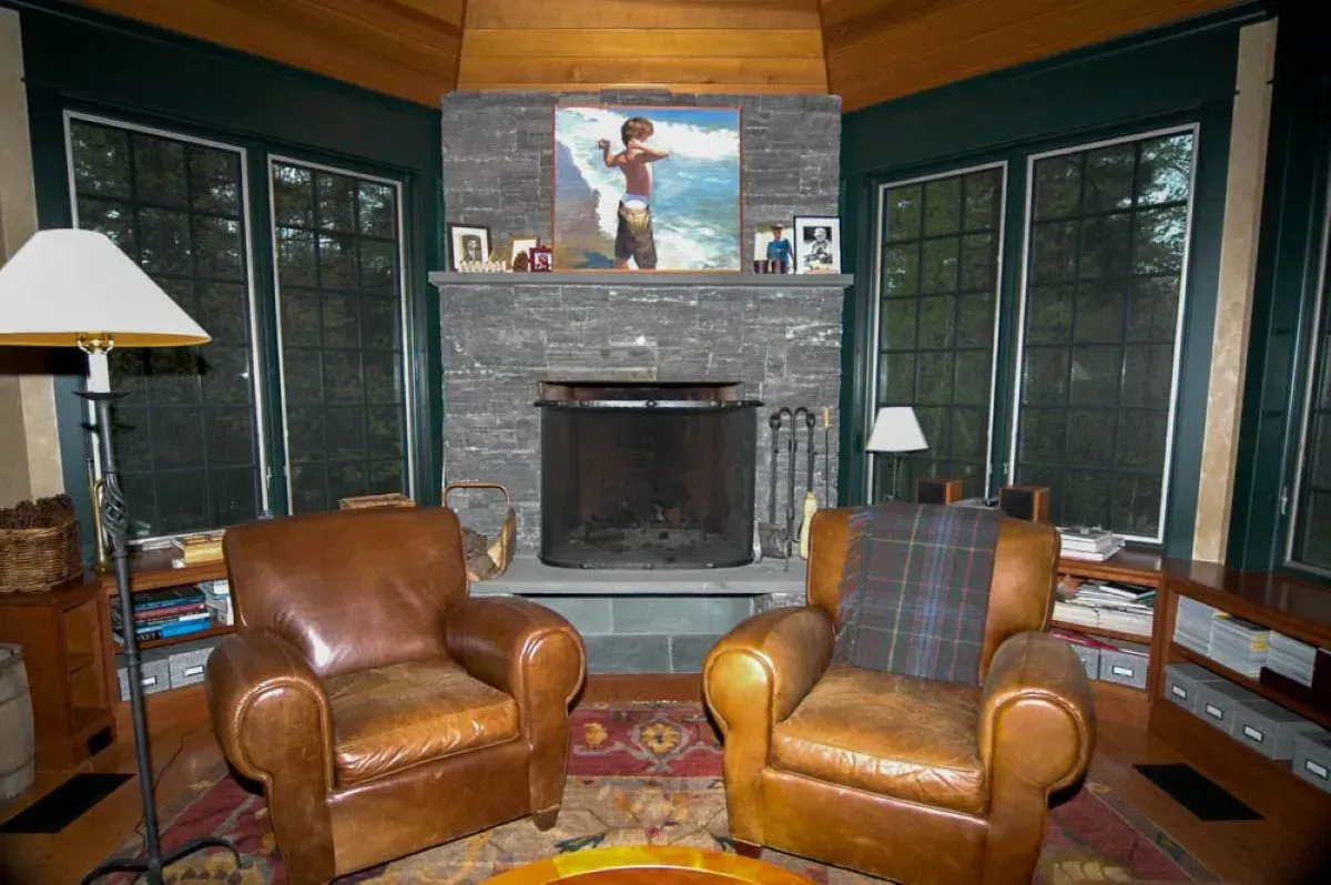 A living room with two leather chairs and a fireplace