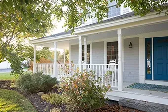A white house with a blue door and porch.