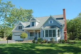 A white house with a gray roof and a red chimney