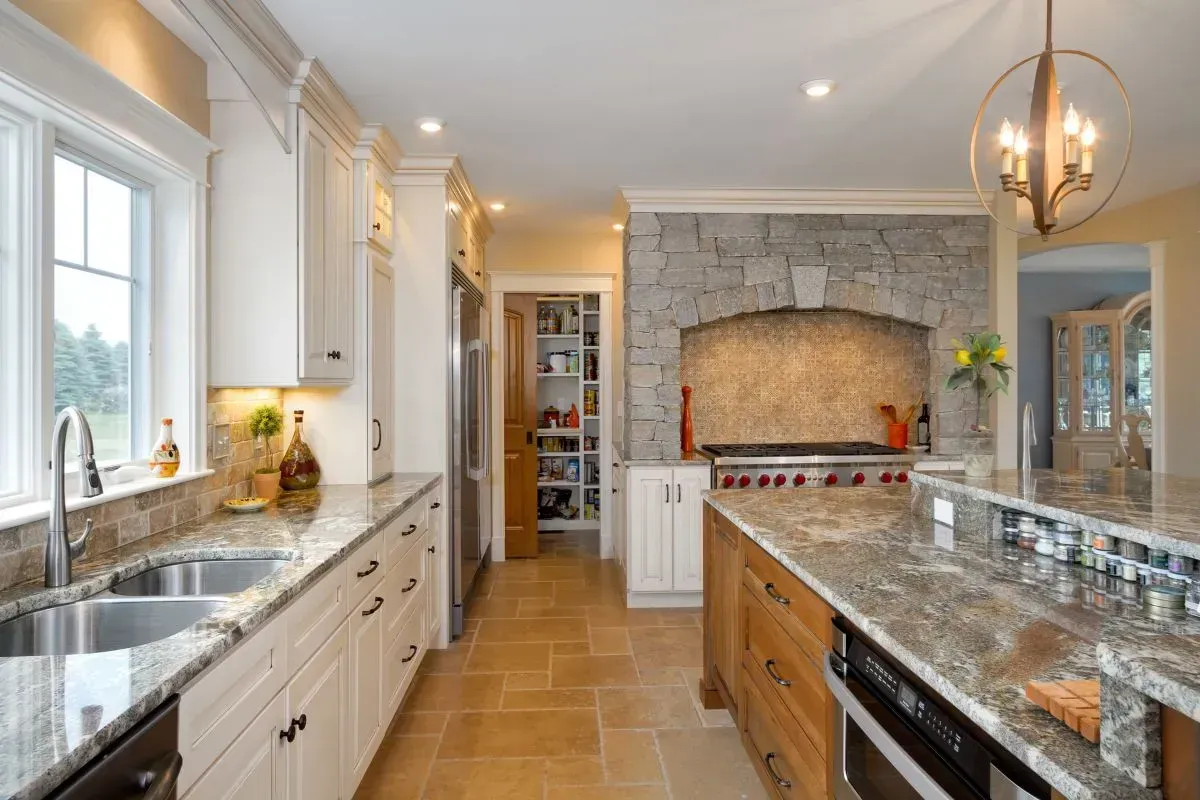 A kitchen with granite counter tops and white cabinets