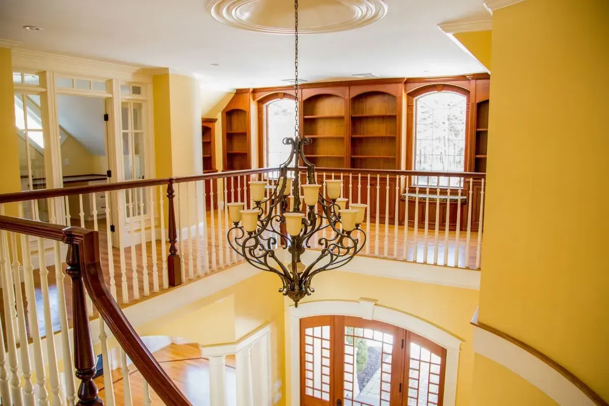 There is a chandelier hanging from the ceiling in the middle of the room.