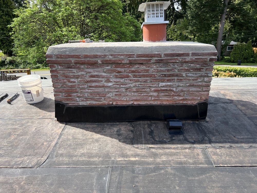 A brick chimney is sitting on top of a roof.