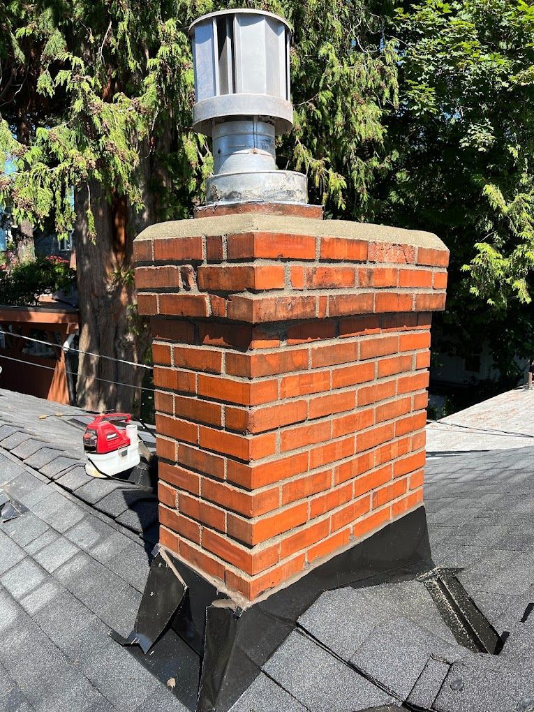 A brick chimney is sitting on top of a roof.