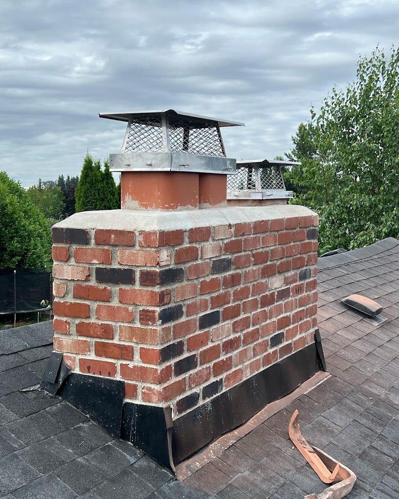 A brick chimney is sitting on top of a roof.