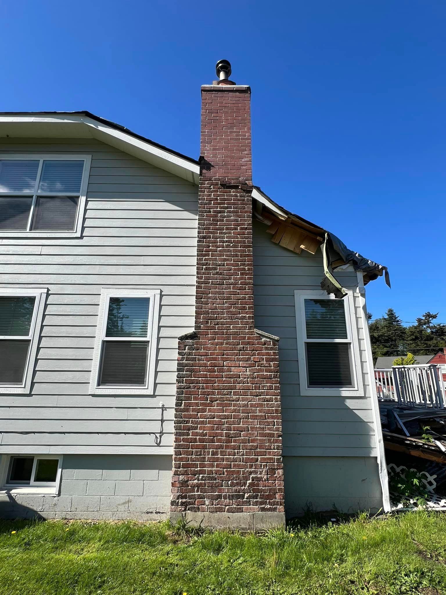 A house with a brick chimney on the side of it.