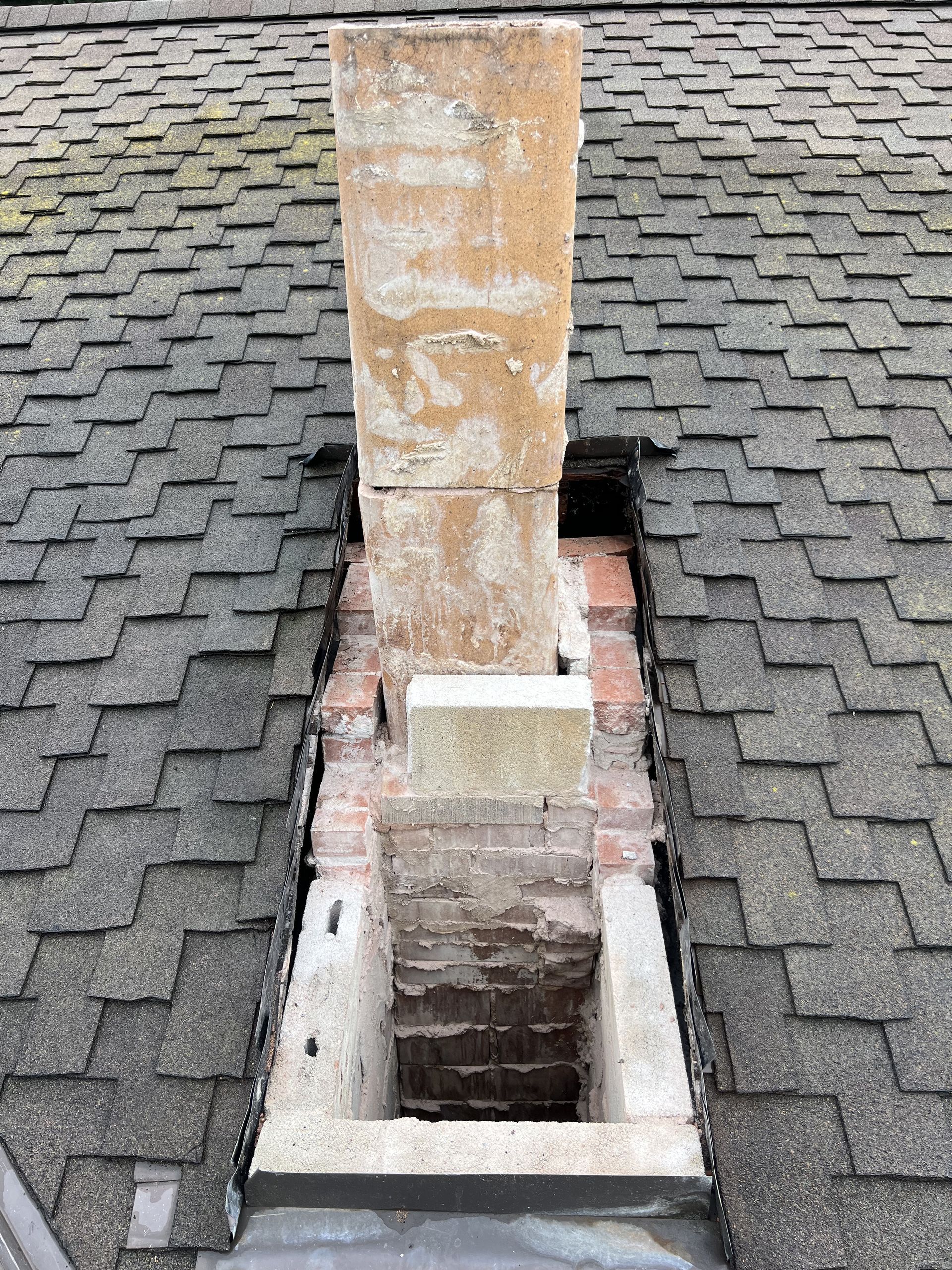 A chimney is sitting on top of a brick roof.