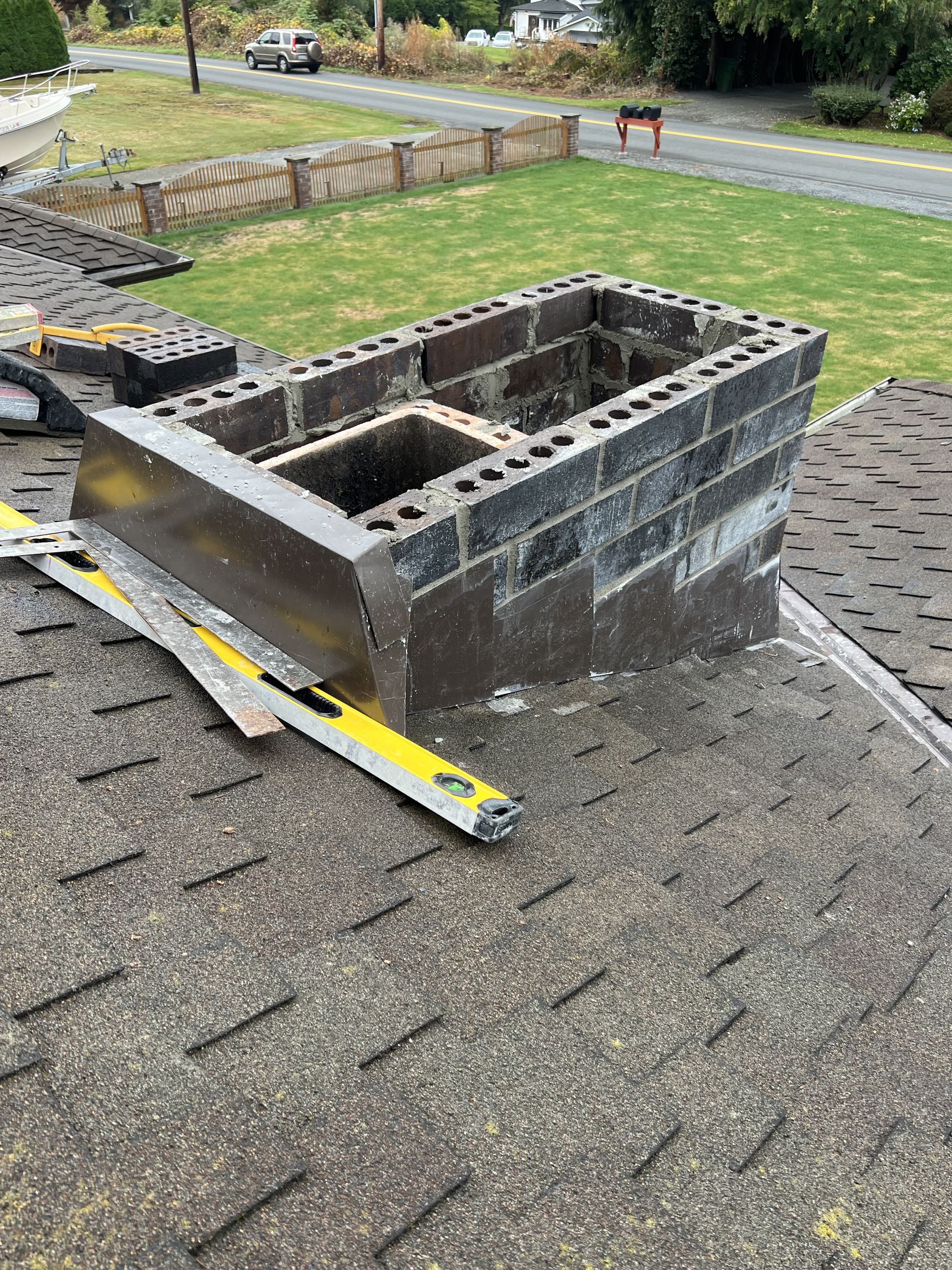 A chimney is being built on the roof of a house.