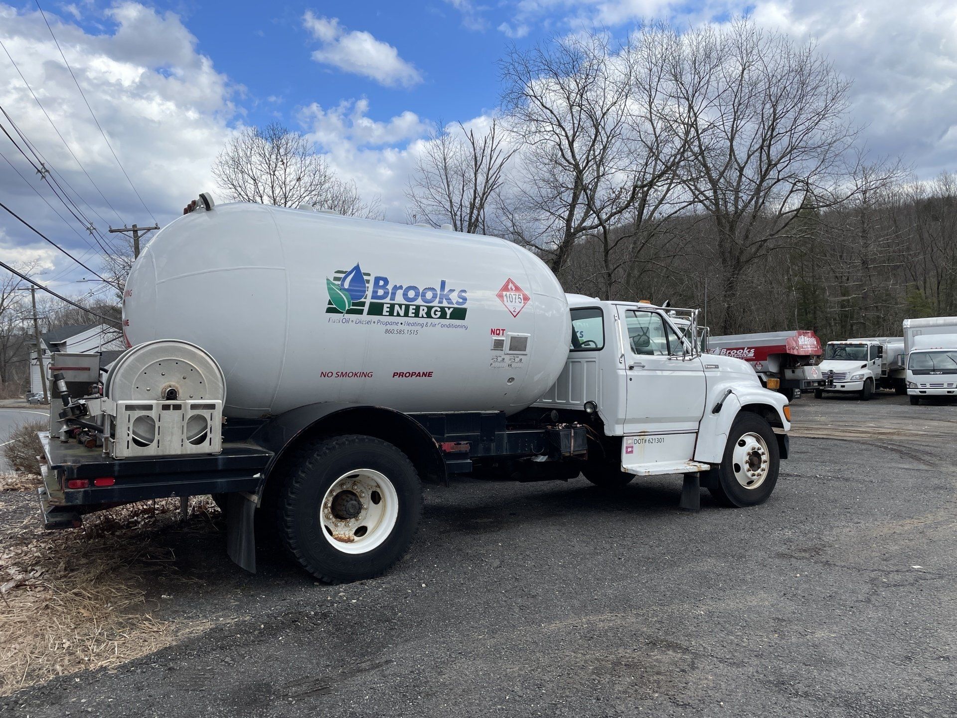 A white tanker truck is parked in a parking lot.