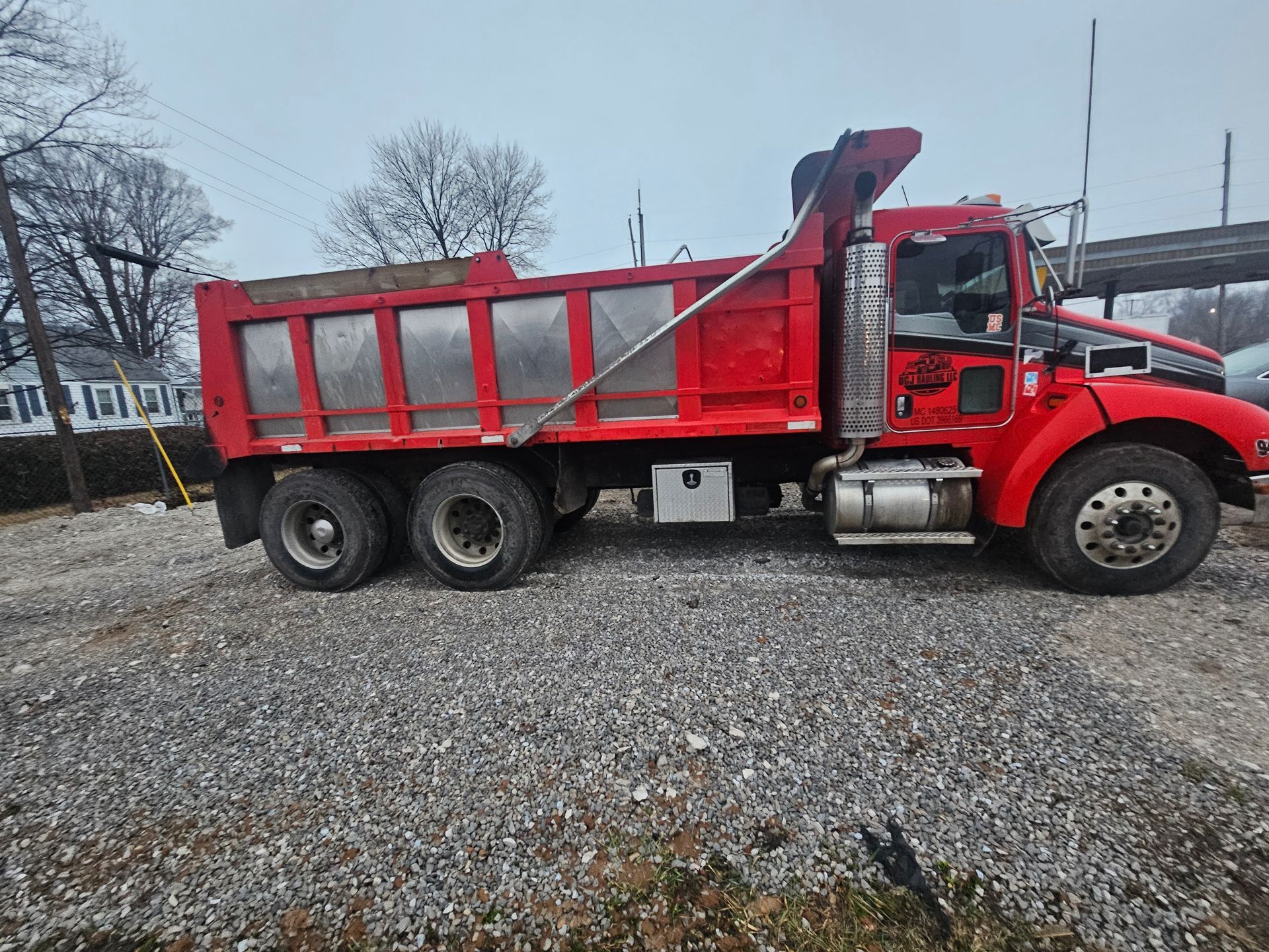 Rear view of a semi-truck approaching a gate with a stop sign.