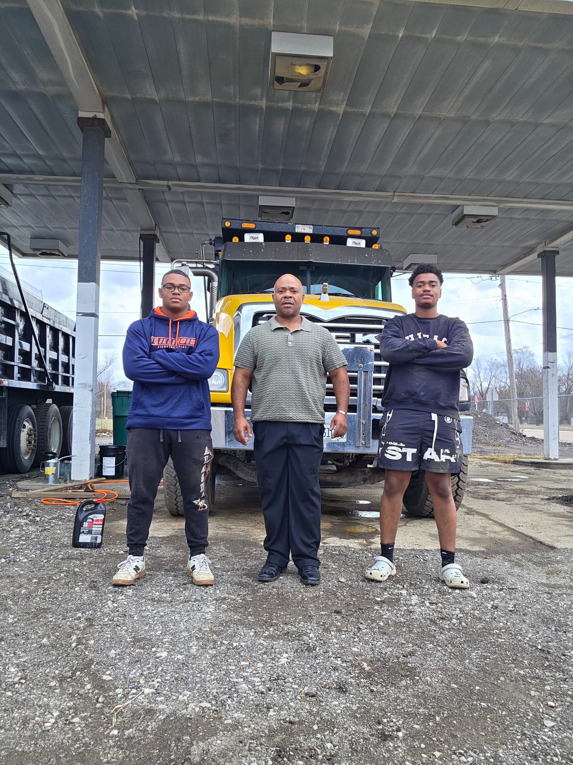 White and red semi-trailer truck parked in a lot, with trees in the background.