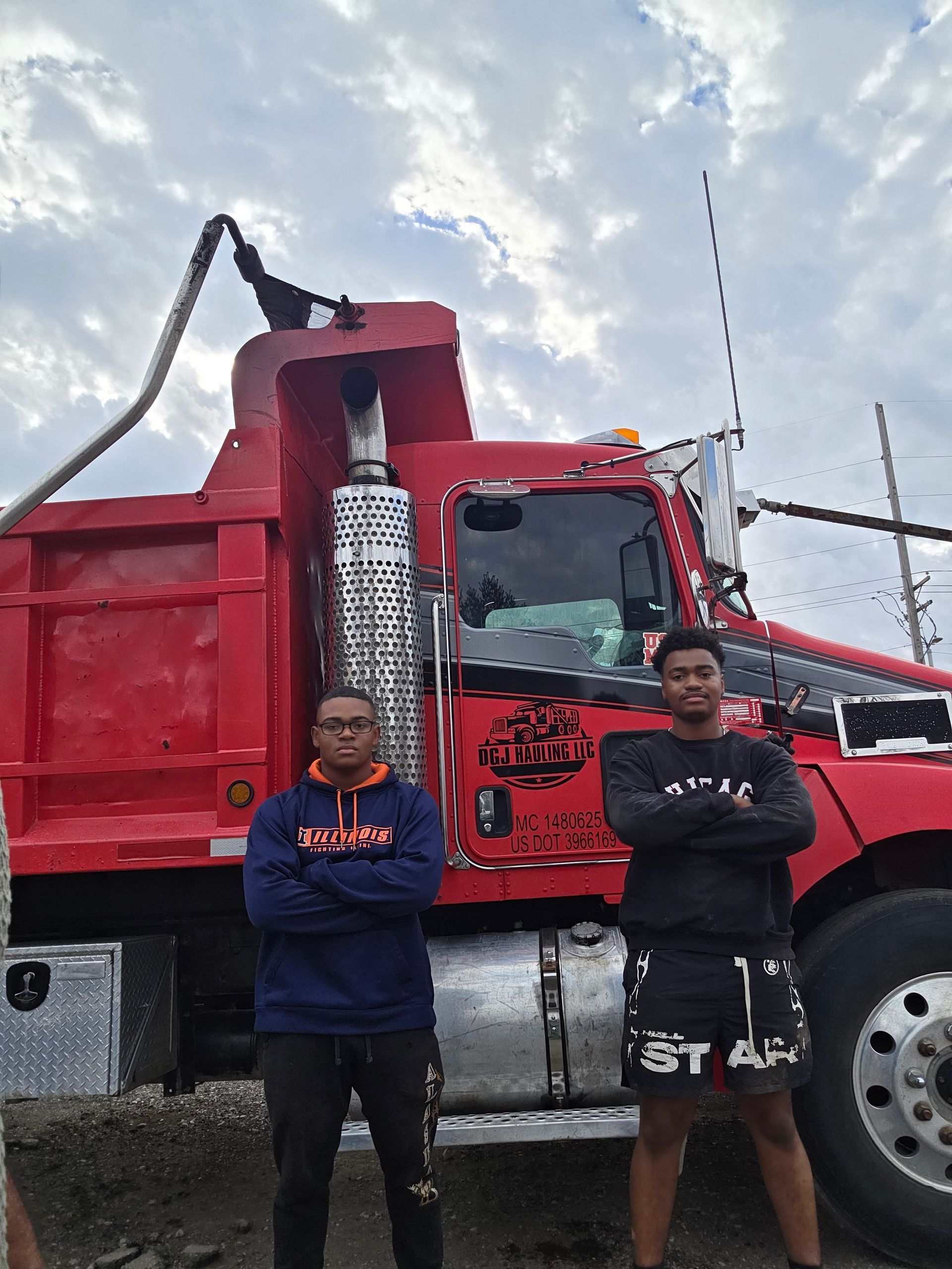 Person driving a car, hands on the steering wheel, wearing a plaid shirt.