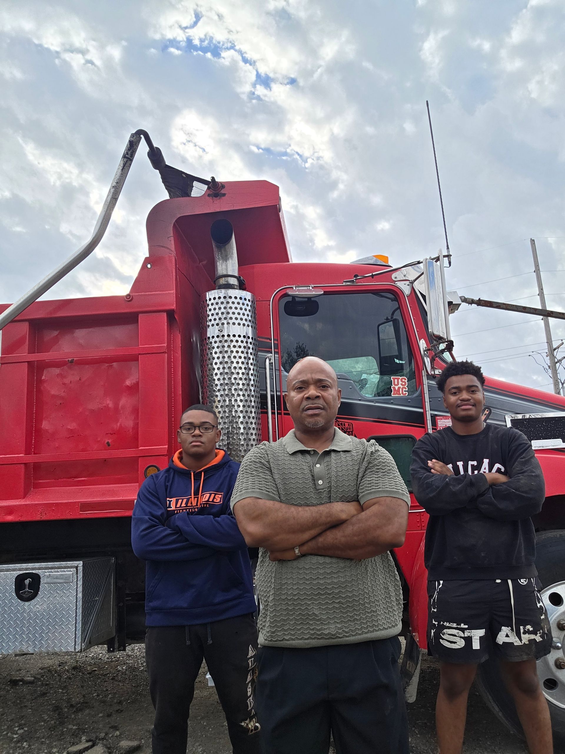 Shiny, chrome truck chassis with two covered compartments, exhaust pipe, and rear tires in a garage.