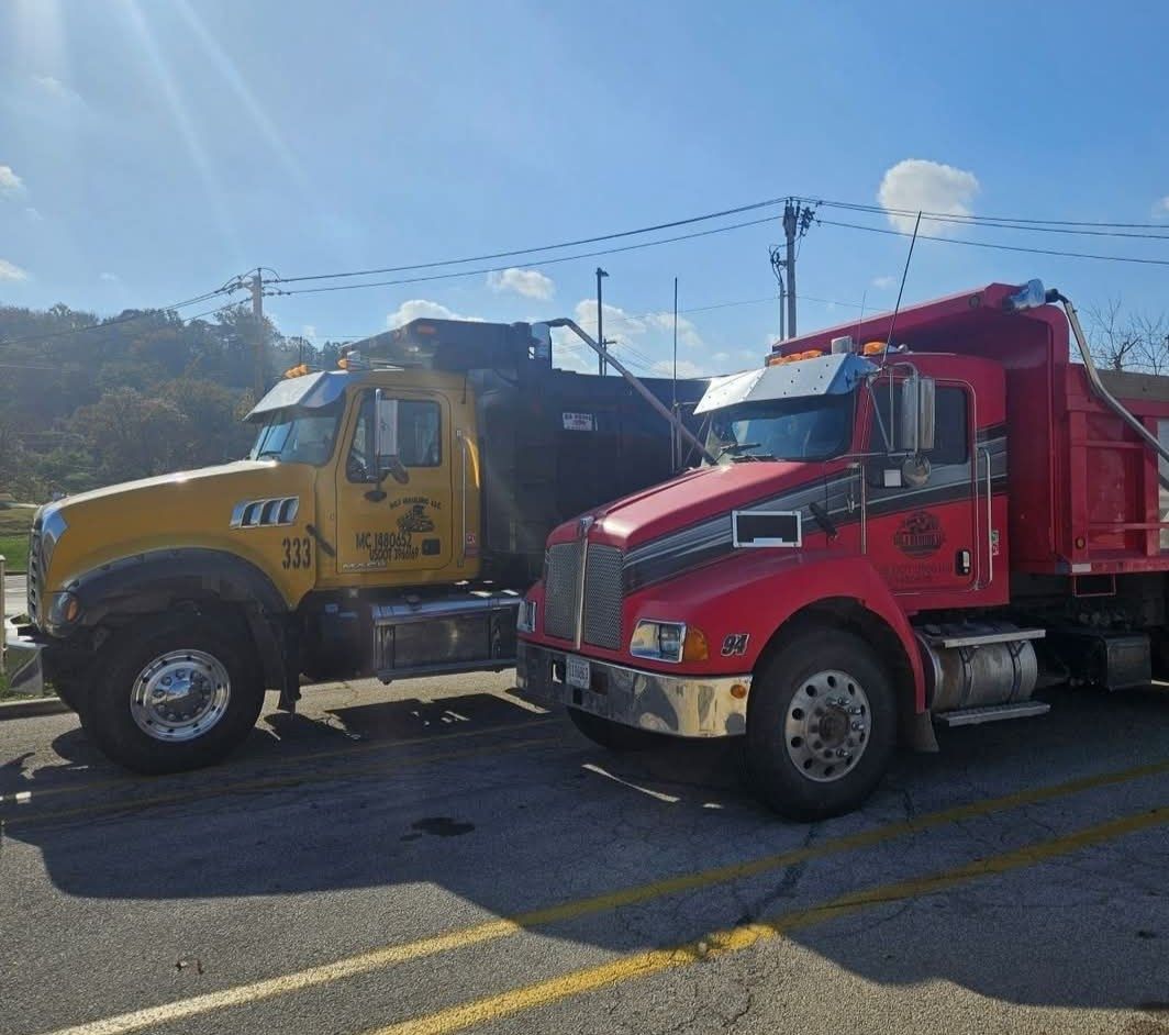 View from inside a car driving on a highway, passing large trucks on a sunny day.