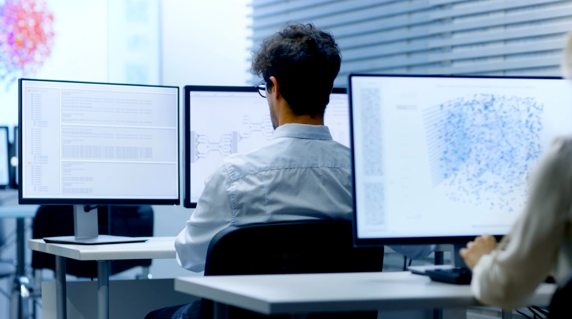 Data analysts reviewing complex social forensic data visualizations on multiple monitors