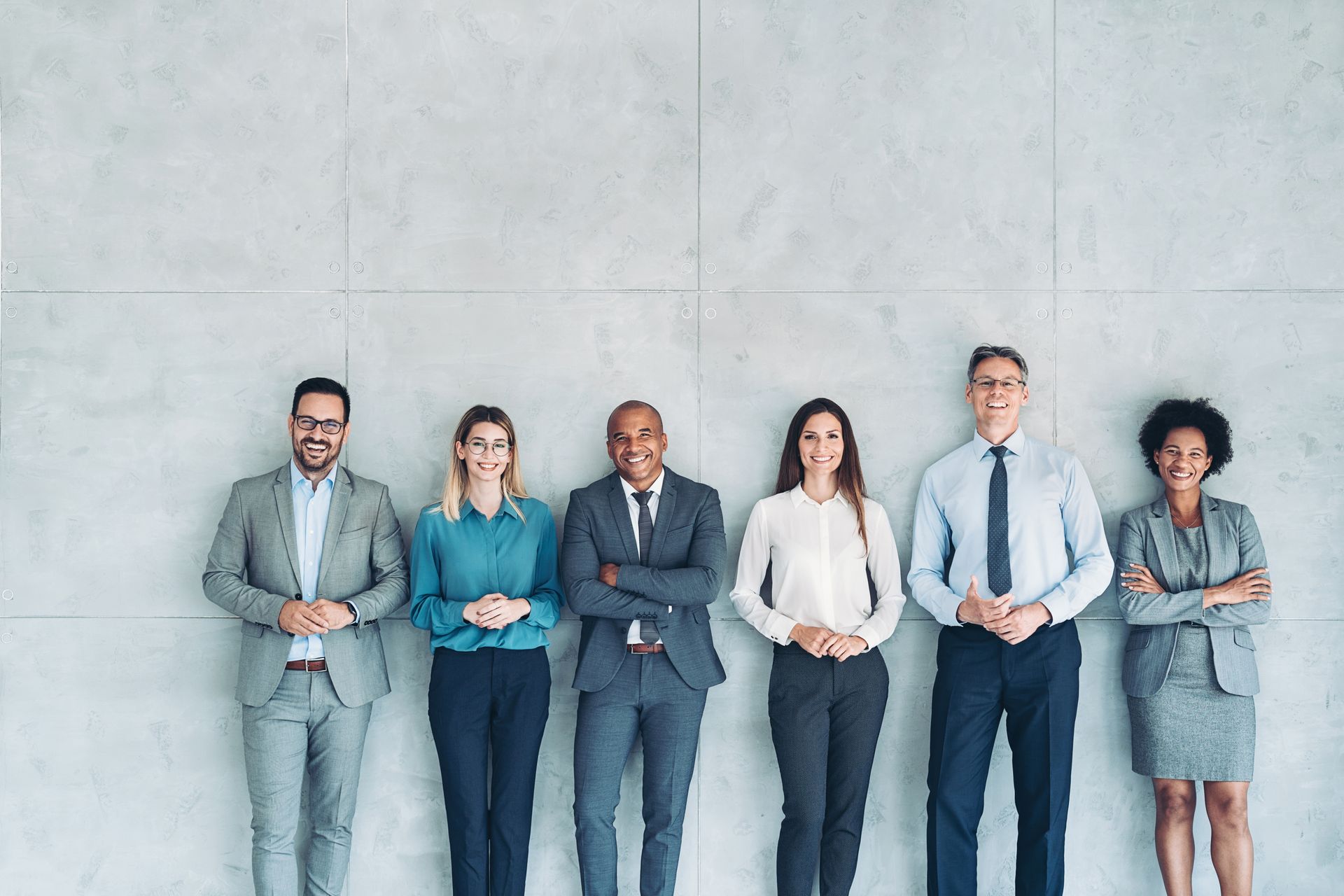 A group of business people standing next to each other with their arms crossed.