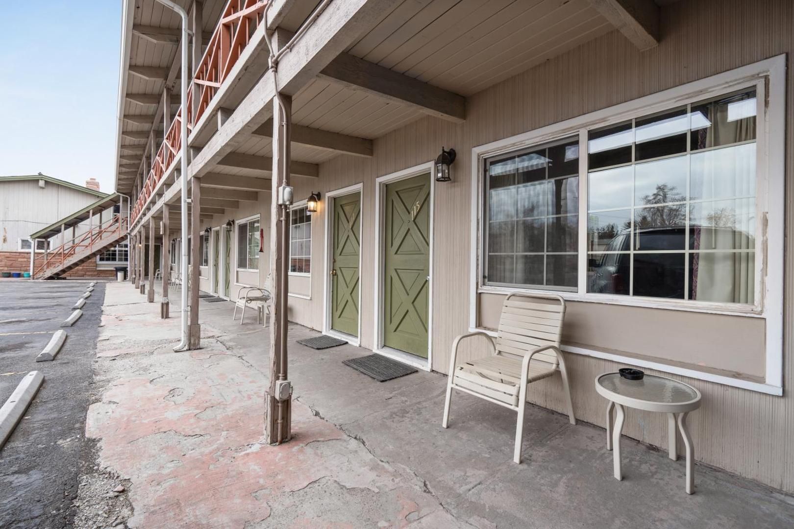 A motel with a bench and a table in front of it.
