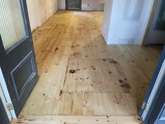 A wooden floor in a room with a door open