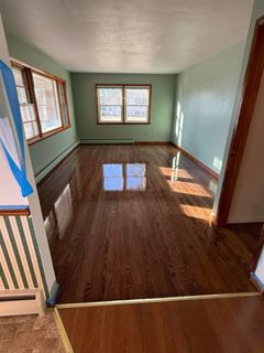A living room with hardwood floors and green walls.